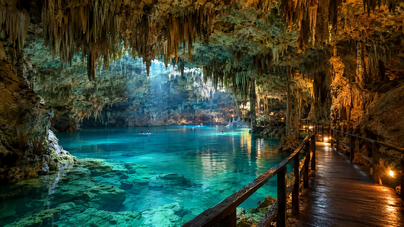 Lit limestone cavern with a turquoise underground river