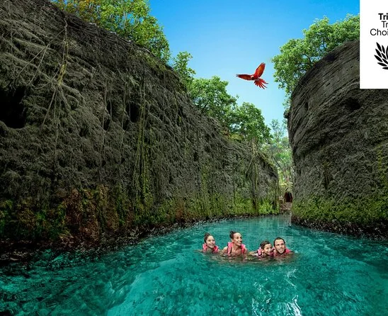 Swimmers in a turquoise river between rock walls at Xcaret