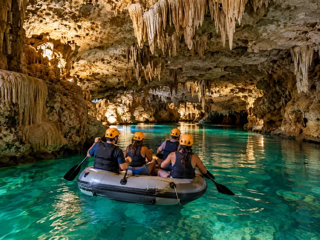 Four people in helmets paddling a raft through a lit cave
