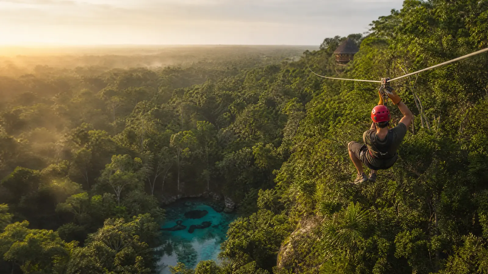 Zipline rider flying over the jungle canopy of the Riviera Maya
